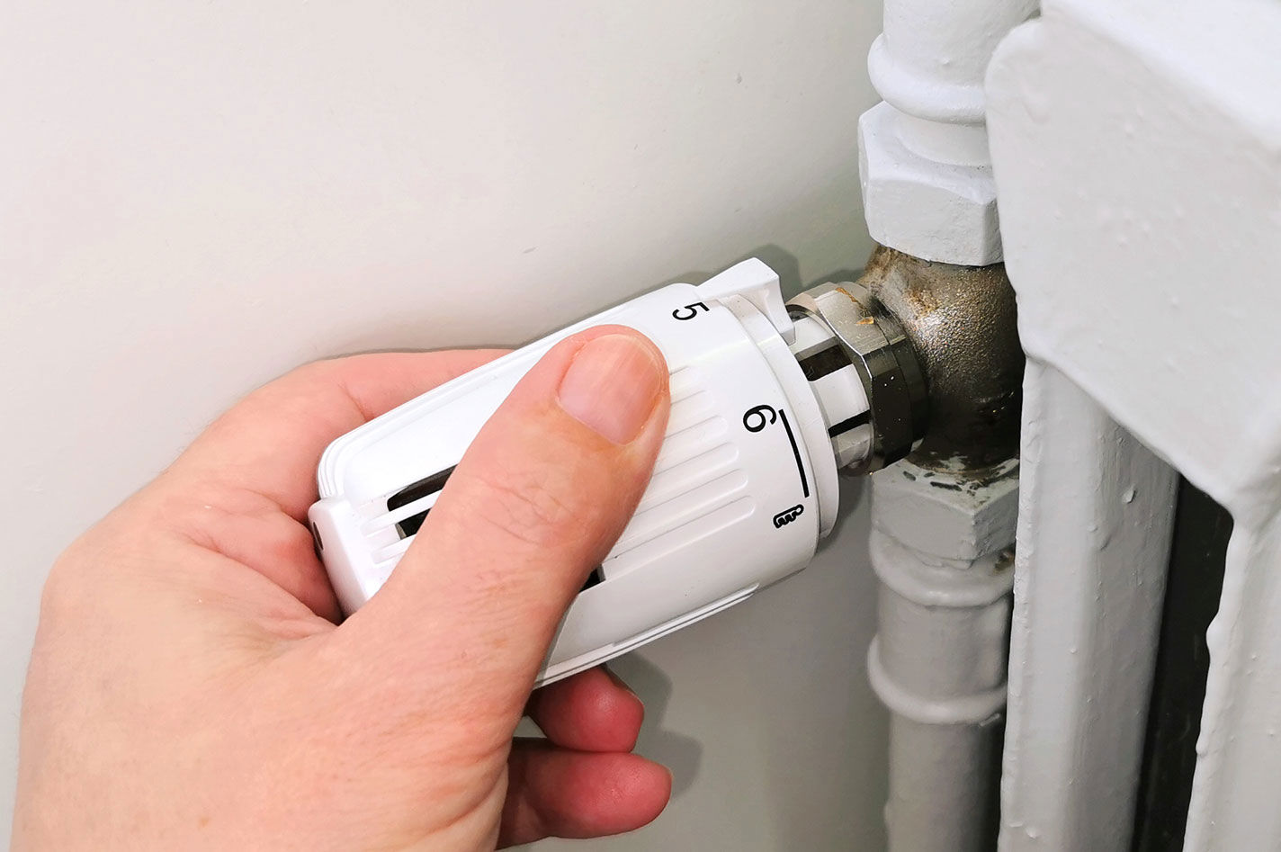 En hånd på en termostat