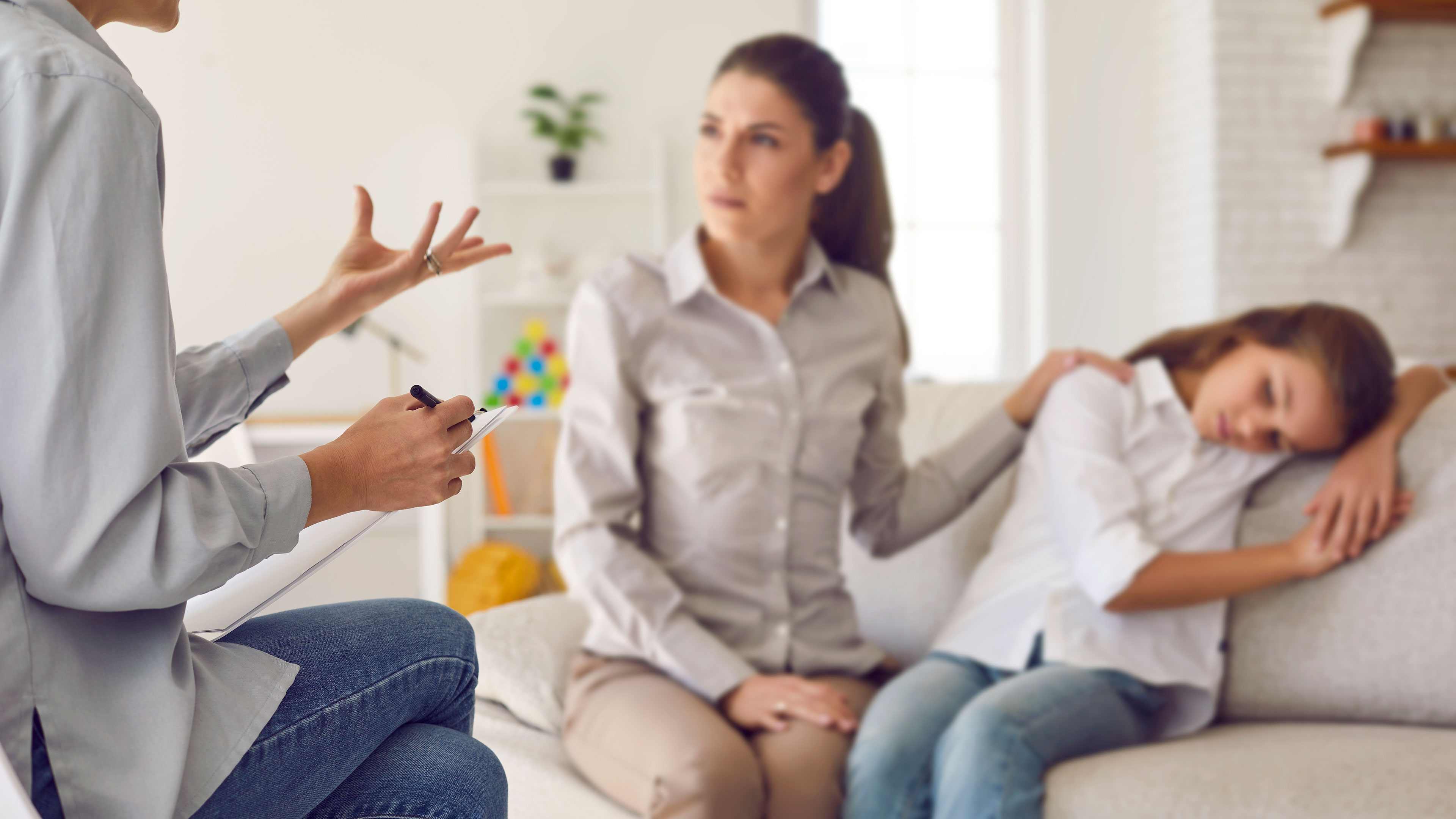 Mor med hånden på sin datters skulder mens hun modtager rådgivning