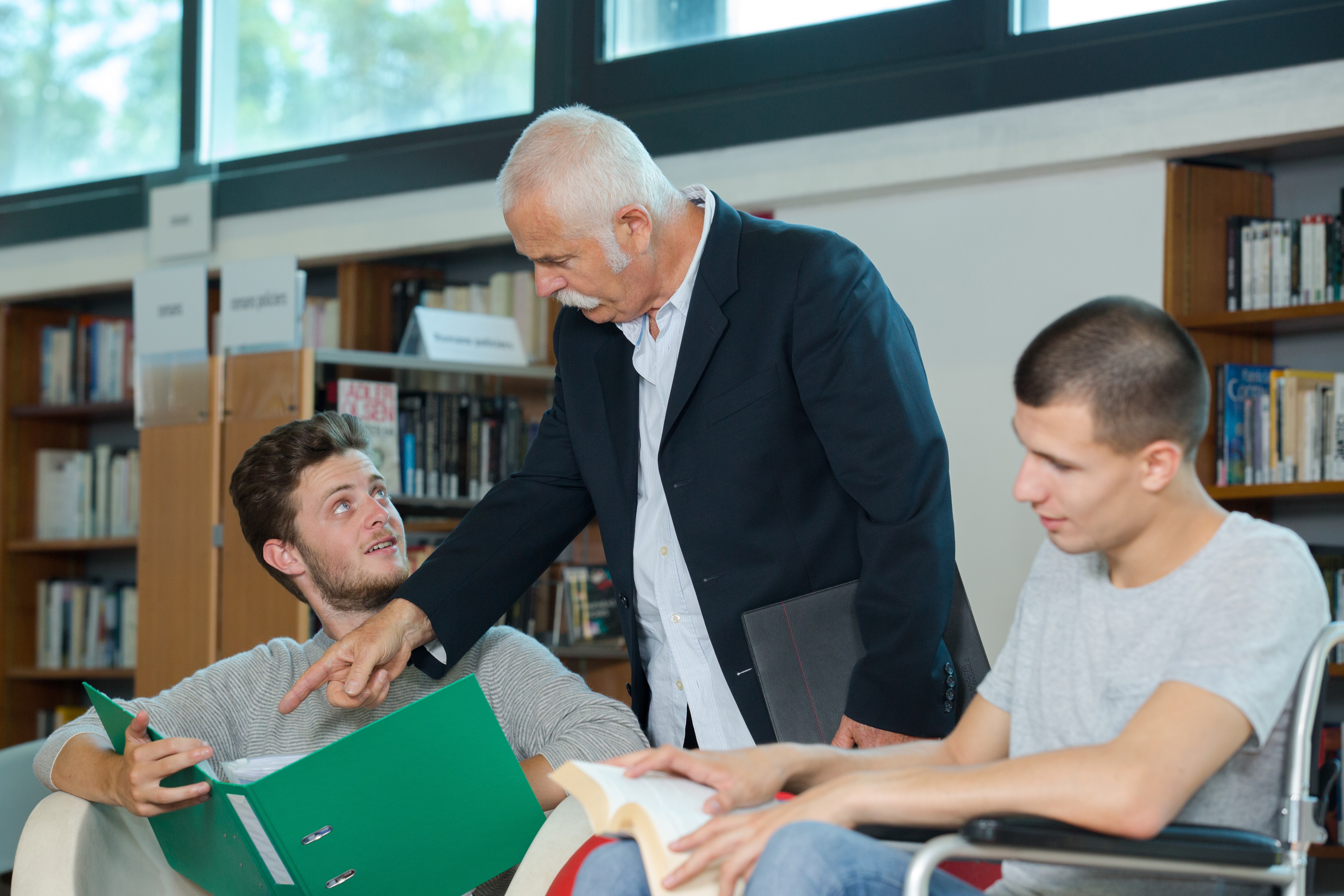 Tre mænd, der kigger i bøger