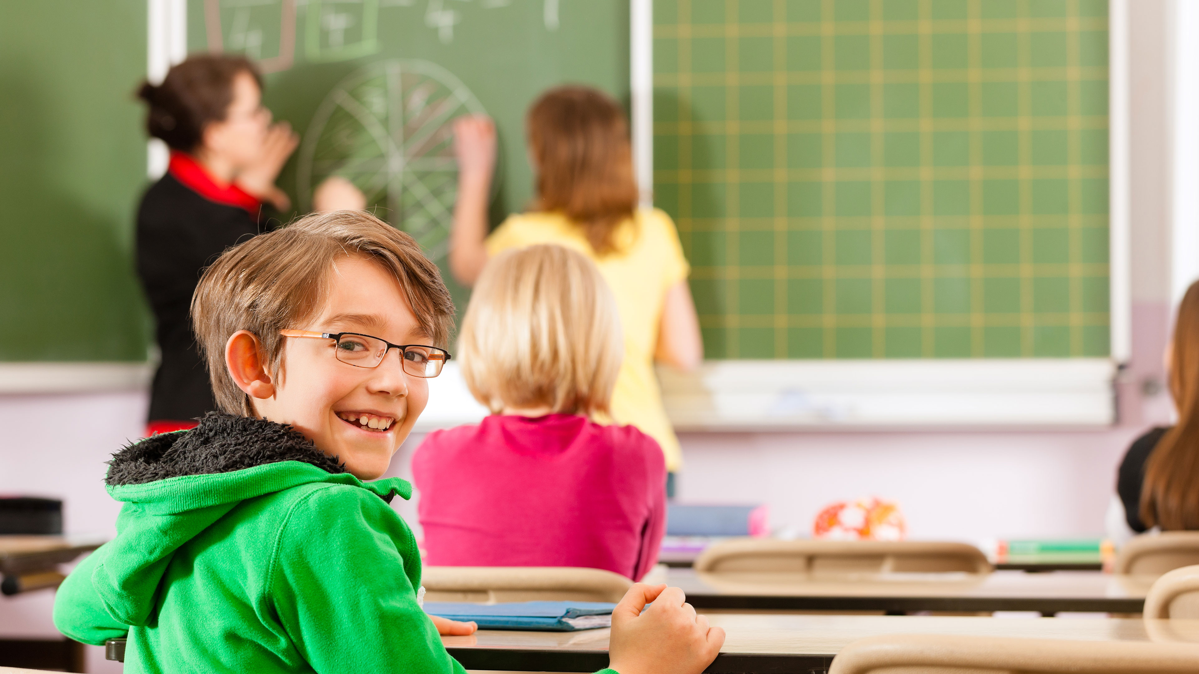 En smilende skoleelev i en skoleklasse // Foto: Colourbox
