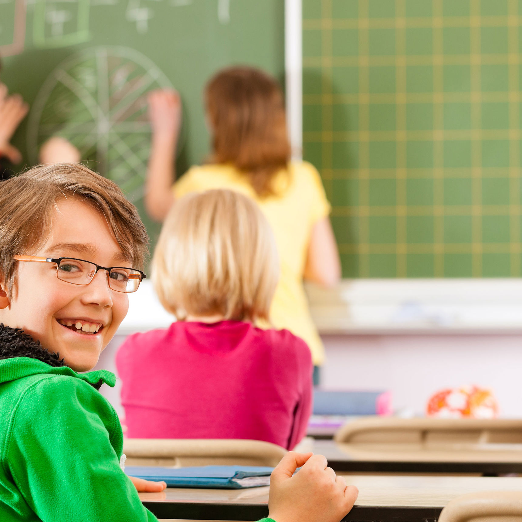 En smilende skoleelev i en skoleklasse // Foto: Colourbox