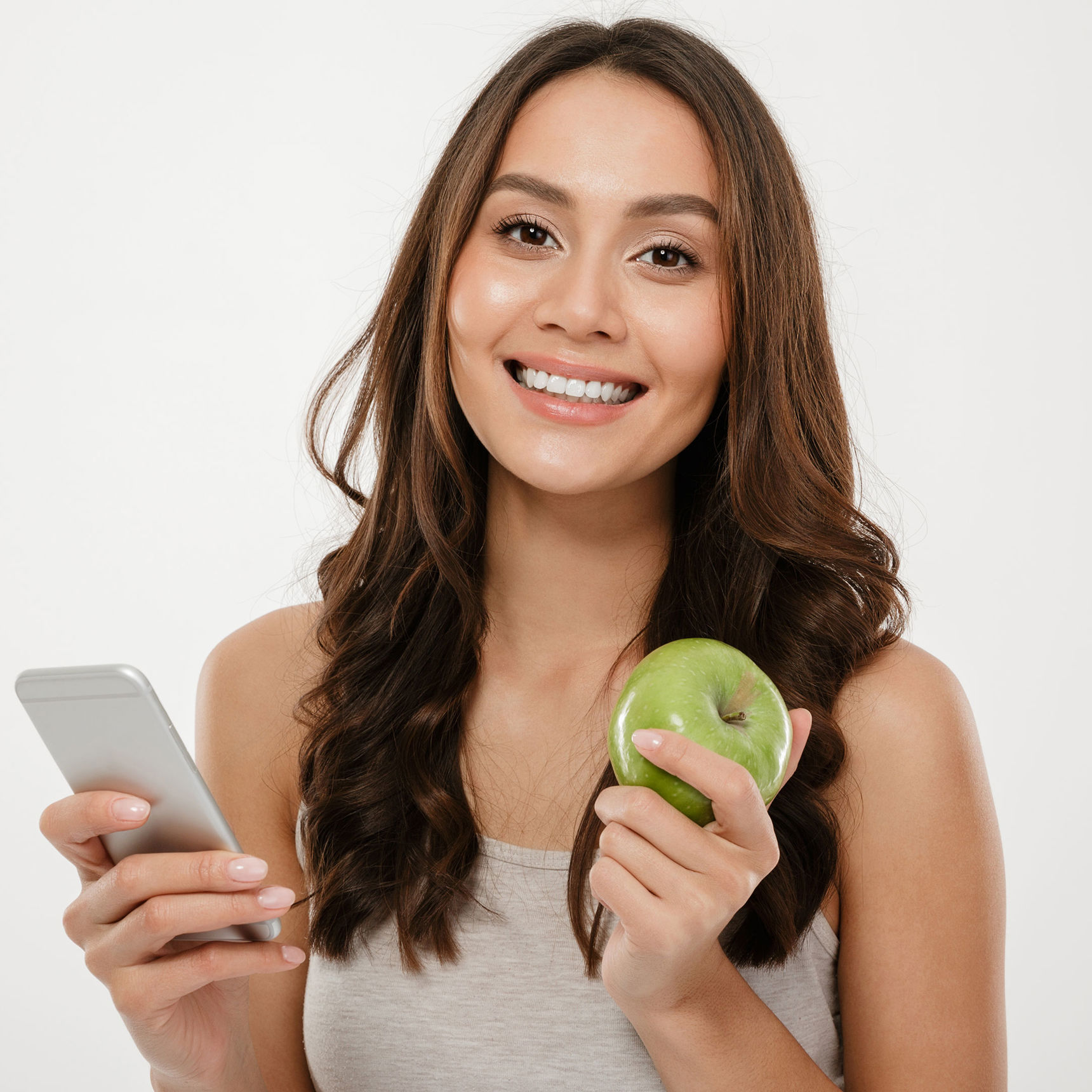 En ung kvinde der holder et æble og en mobil