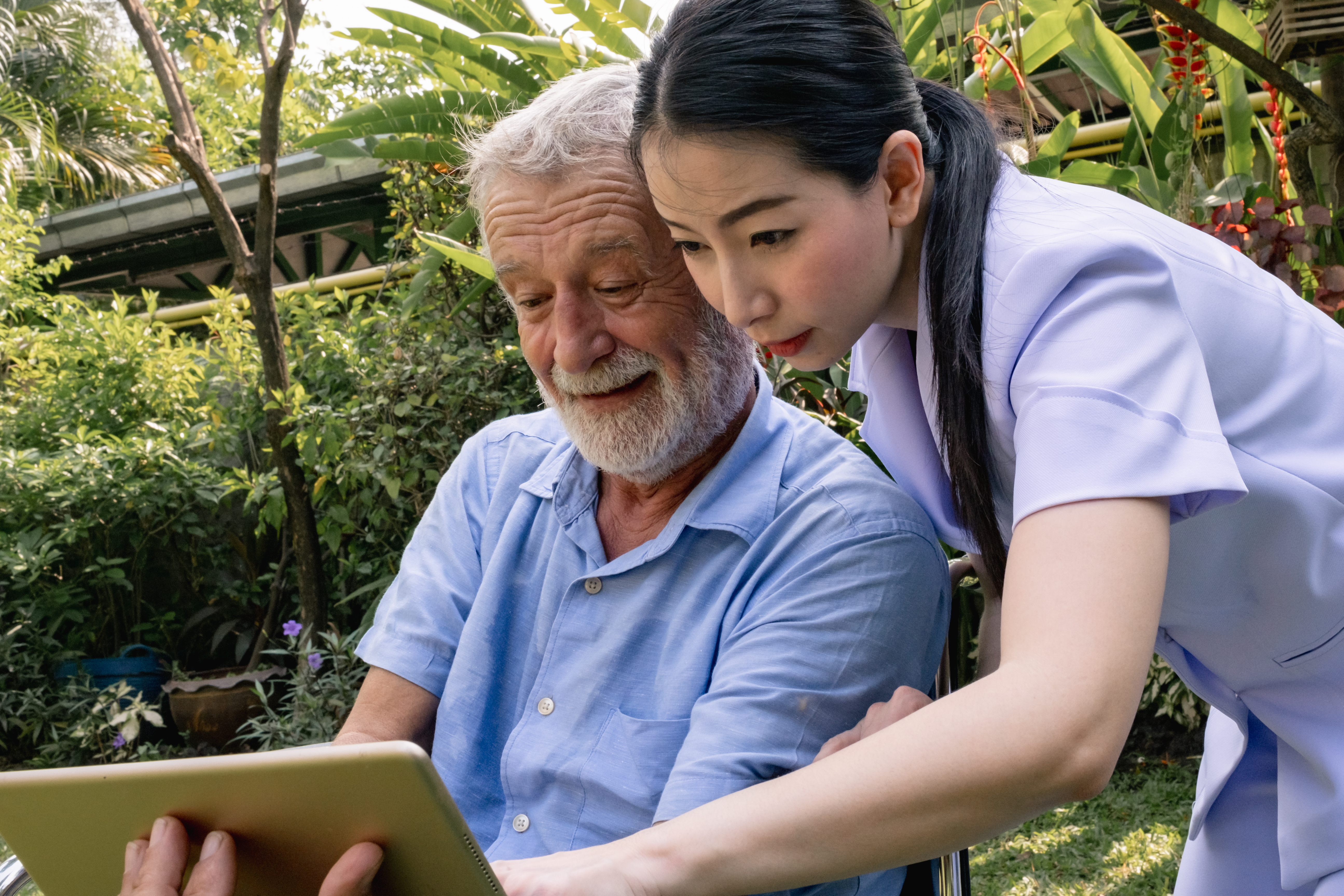 Kvinde med ældre mand kigger på iPad