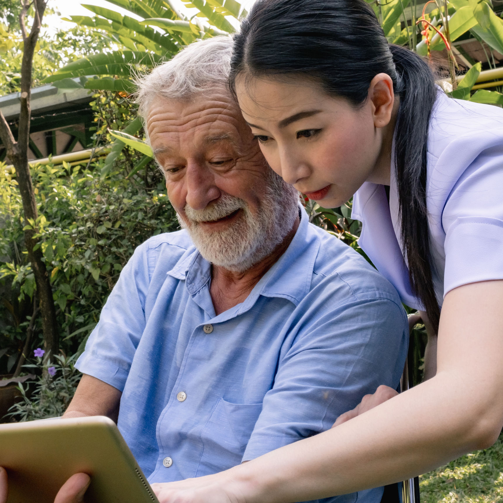 Kvinde med ældre mand kigger på iPad