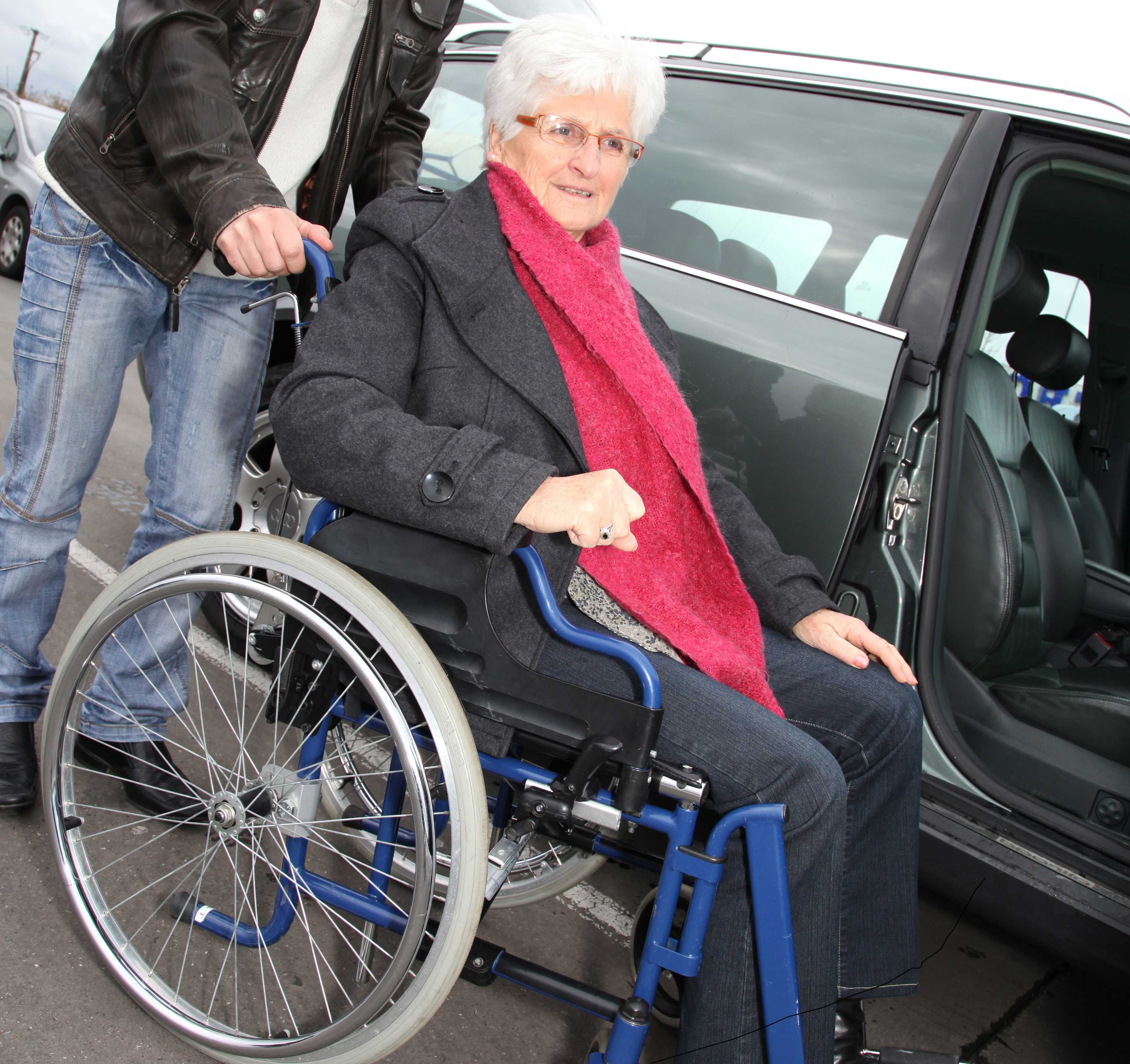 Mand og dame, der gør klar til at køre i handicapbil