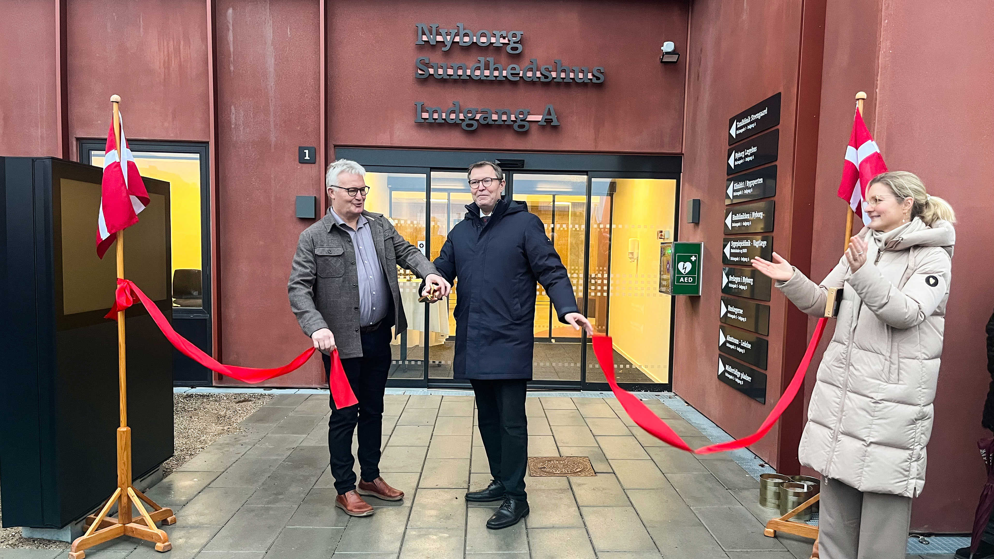 Kenneth Muhs og Jan Reimer Christiansen klipper den røde snor og åbner Nyborg Sundhedhus