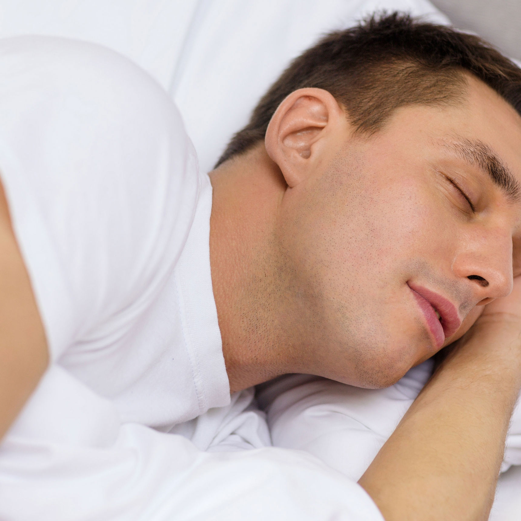 En man der ligger i en seng og sover