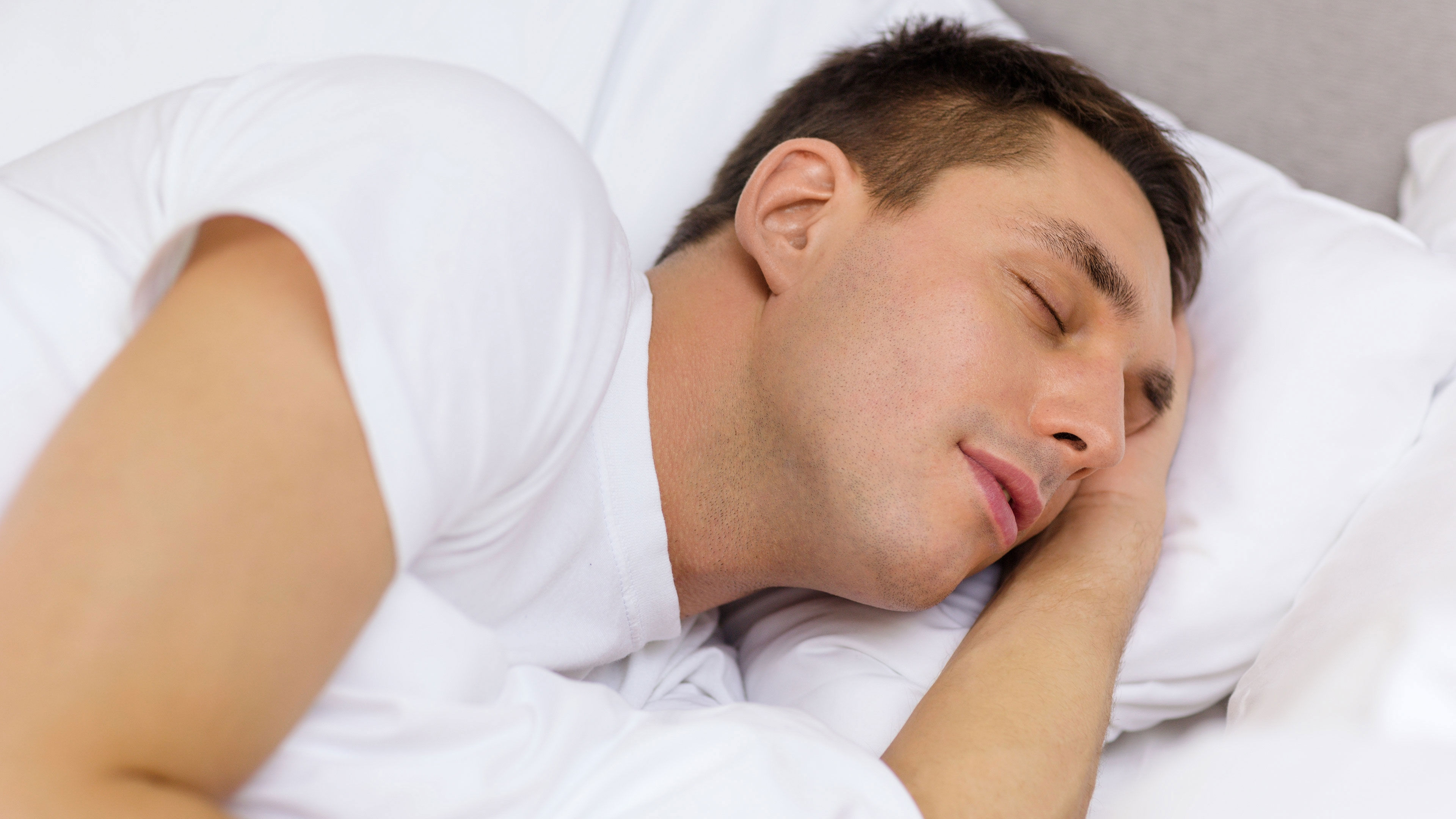 En man der ligger i en seng og sover