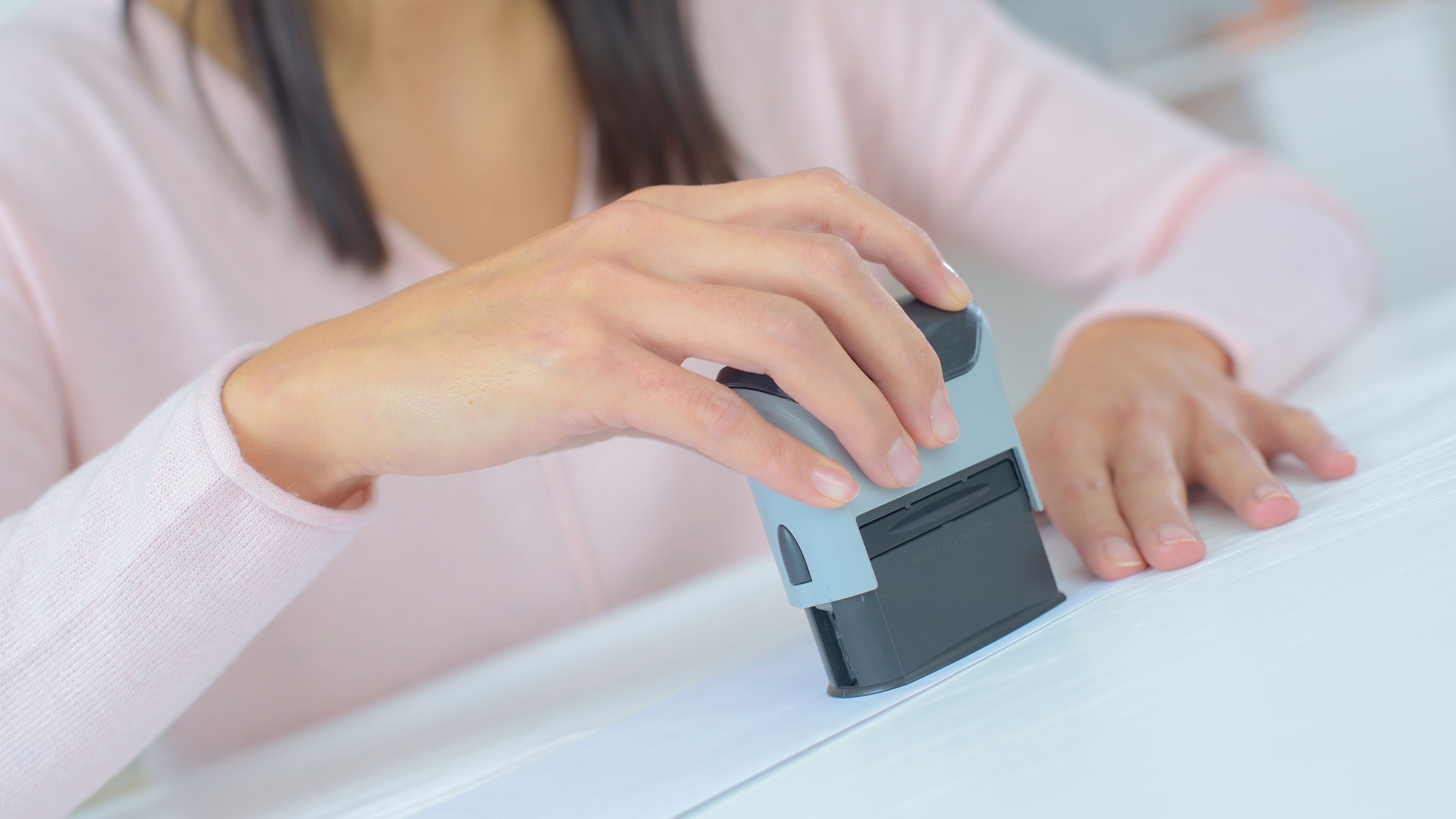 Hånd der sætter et stempel på et stykke papir // Foto: Coloorbox