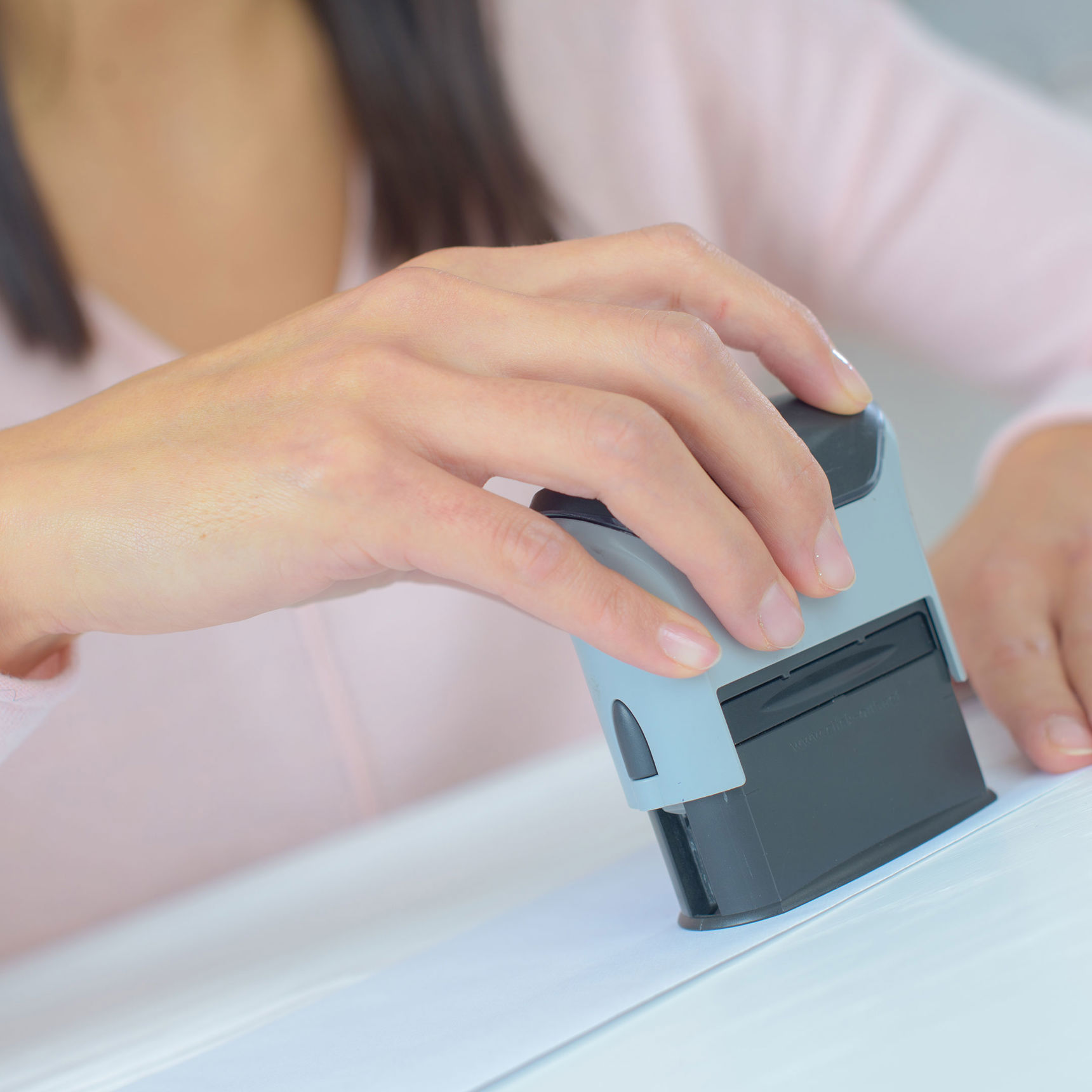 Hånd der sætter et stempel på et stykke papir // Foto: Coloorbox