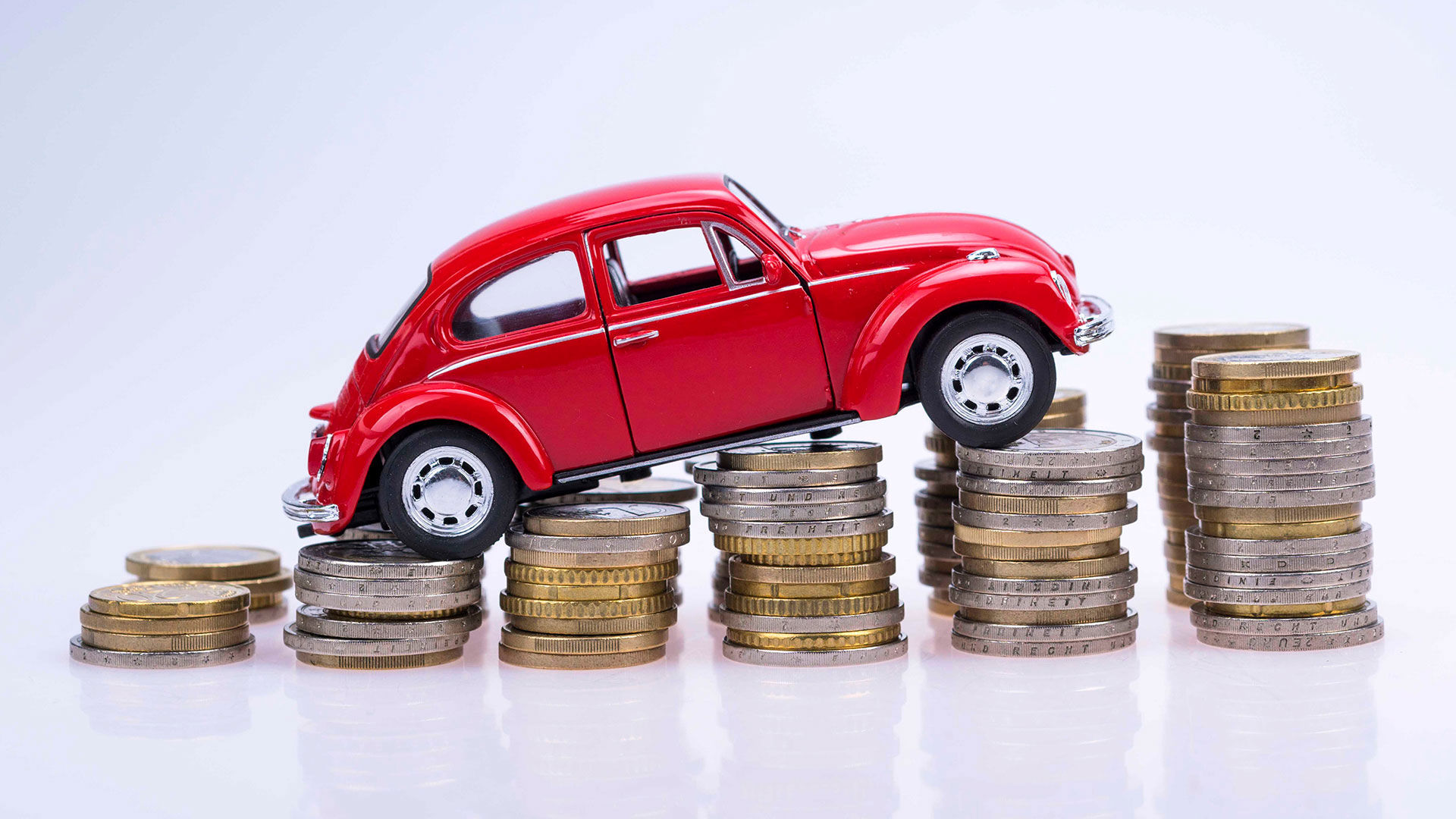 En legetøjsbil sat på en stak mønter