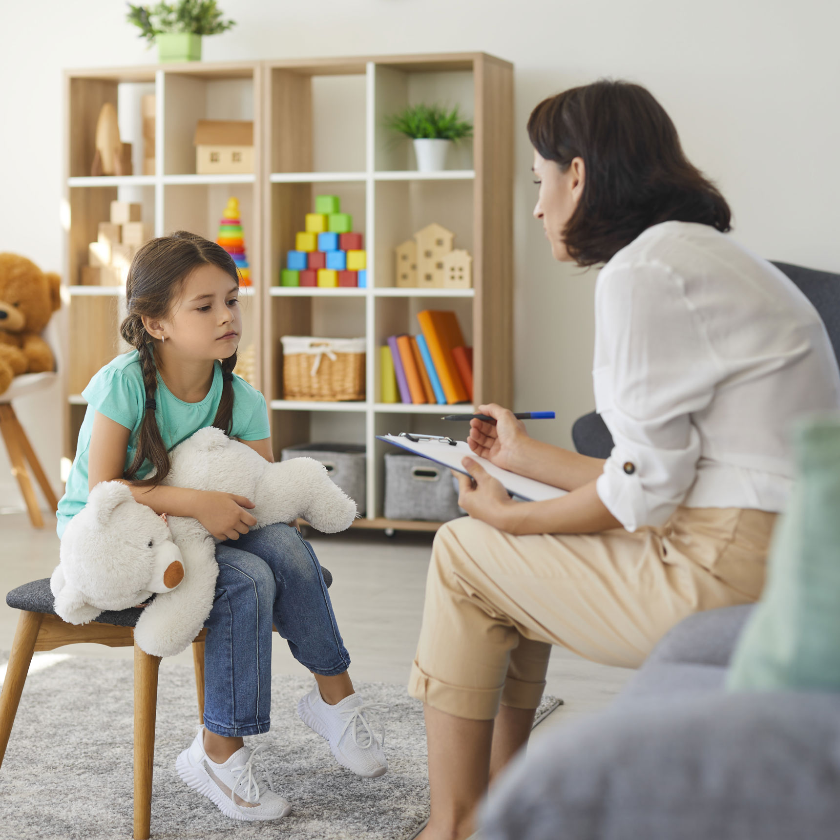 Lille pige der sidder til vejledning hos en dame