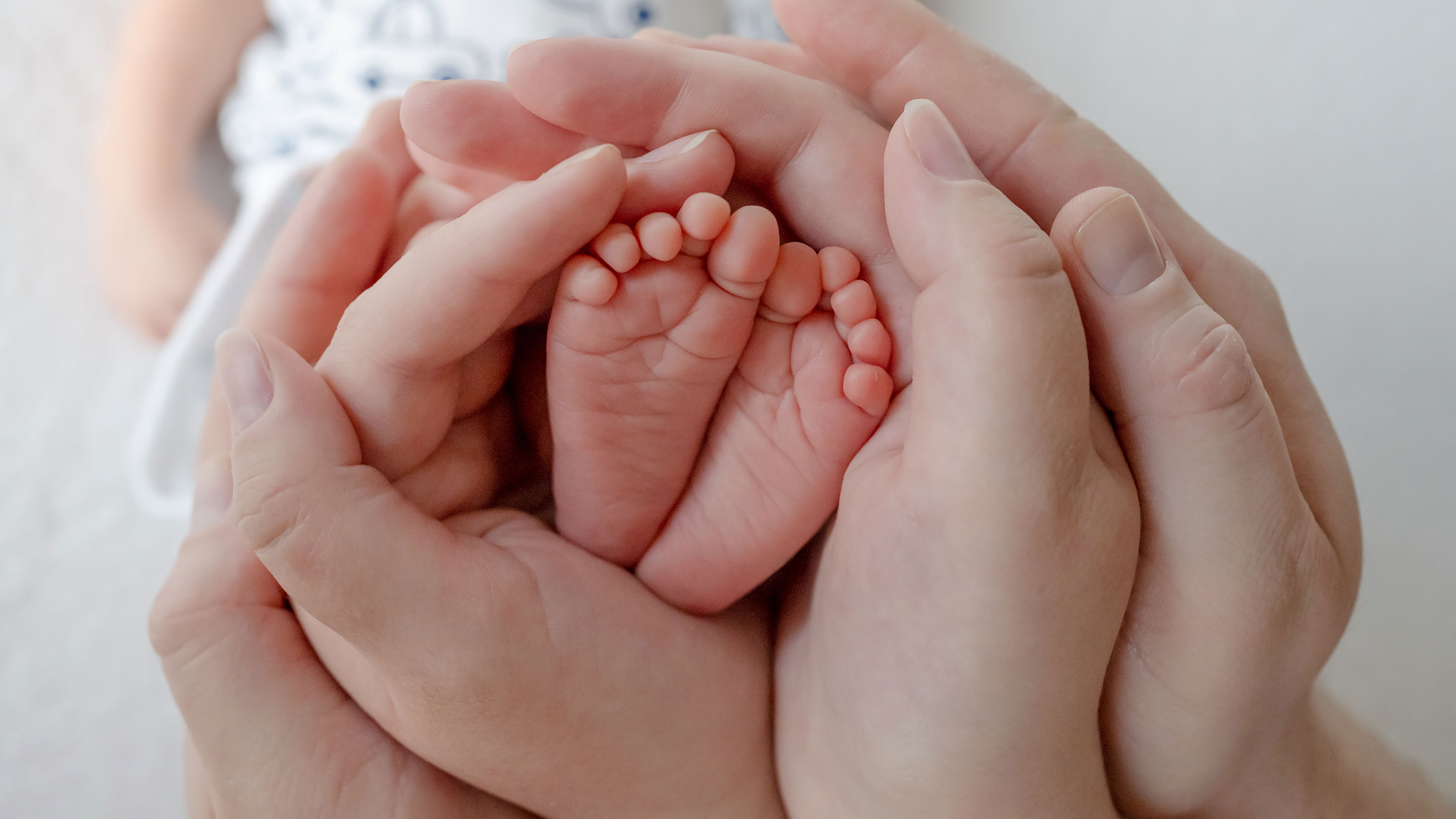 Hænder der holder barnefødder